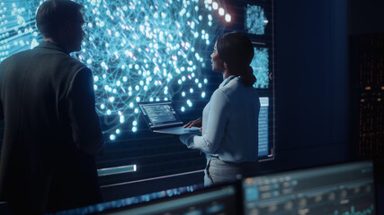 Project Manager and Computer Science Engineer Talking while Using Big Screen Display Showing Neural...