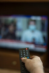 Someone who constantly changes channels while watching TV. selective focus remote control