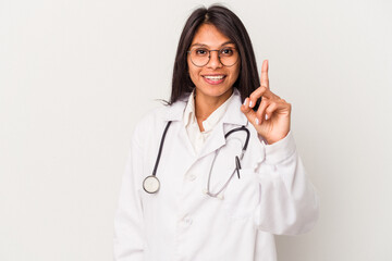 Young doctor latin woman isolated on white background showing number one with finger.