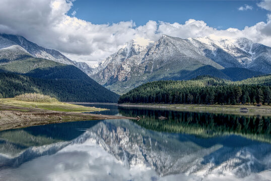 Calm Water Of Mission Reservoir And High Peak Snow Covered Mountains Near St. Ignatius, Montana