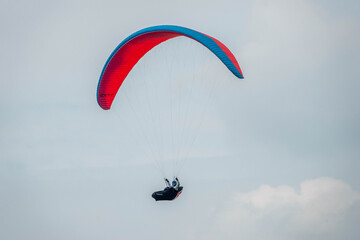 paraglider flying against a background of summer clouds