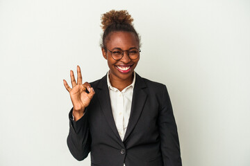 Young business african american woman isolated on white background winks an eye and holds an okay gesture with hand.