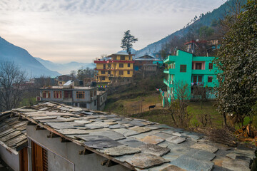 Fototapeta na wymiar a roof made of thin stone plates nailed to a wooden beam and town Kullu