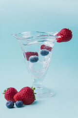 Vertical shot of glass tulip cup with various fruits.
