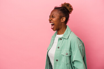 Obraz na płótnie Canvas Young african american woman isolated on pink background shouting very angry, rage concept, frustrated.