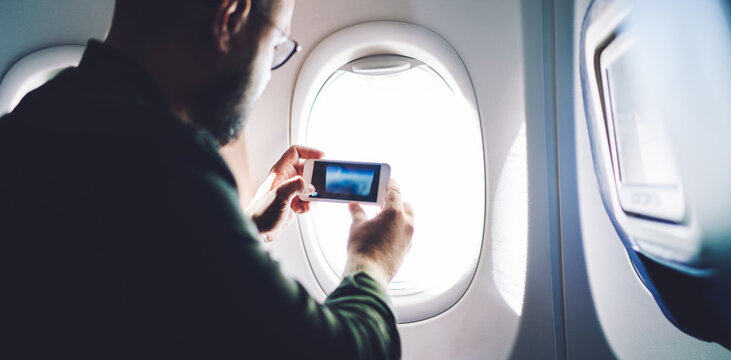 Passenger taking photo through aircraft window