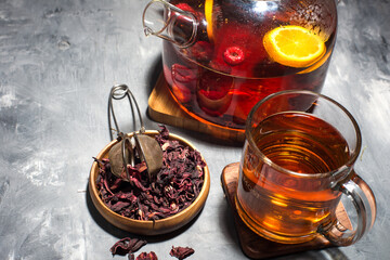 Dry tea leaves, raspberries and tea in a glass teapot