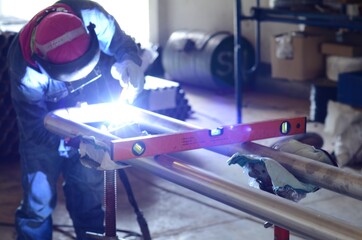 worker with protective mask welding metal