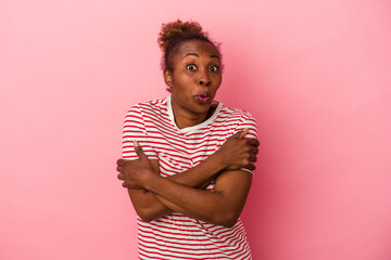 Young african american woman isolated on pink background shrugs shoulders and open eyes confused.