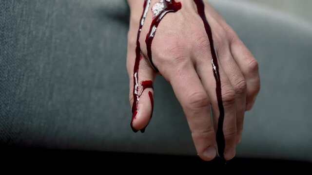 Blood drips from the hand of the murdered man