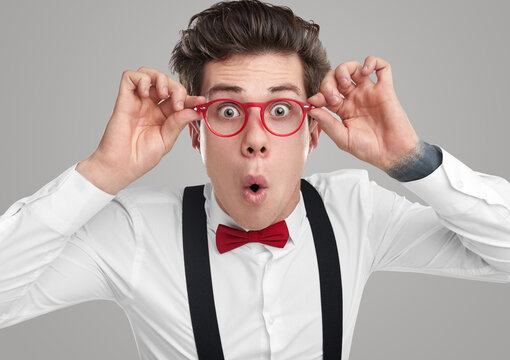 Funny geek in glasses looking at camera