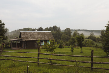 a wooden farmhouse in a country scene on a cloudy day
