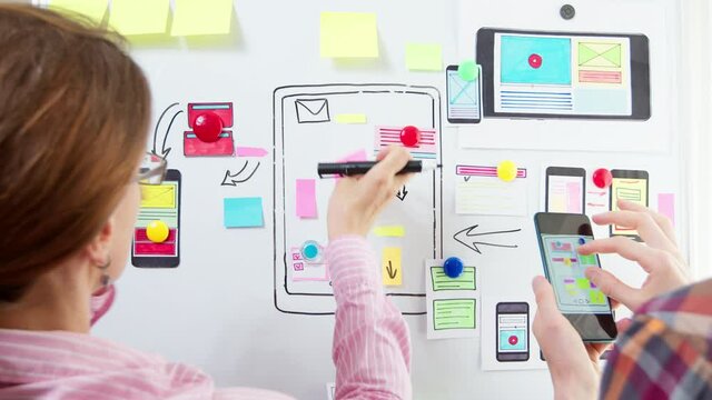 Designers are developing a web application for mobile phones. The creators are working on a sketch of the interface for the smartphone. User experience.