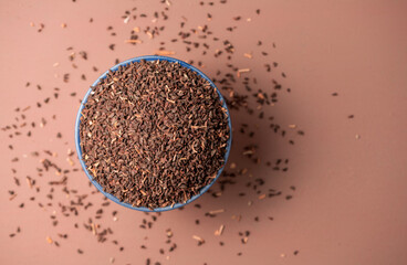 Peganum harmala seeds in a bowl, top view. Copy space. Peganum harmala is also called -Syrian rue- and contains harmala alkaloids such as harmine, harmaline and tetaphydroharmine.