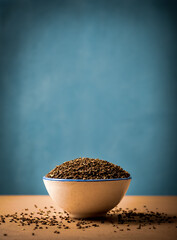 Peganum seeds in a bowl with copy space. Peganum harmala, commonly called wild rue, Syrian rue or African rue. From ancient times, it has been claimed to be an important medicinal plant.