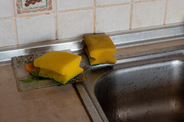 Clean and dirty dish sponges on kitchen sink, close-up