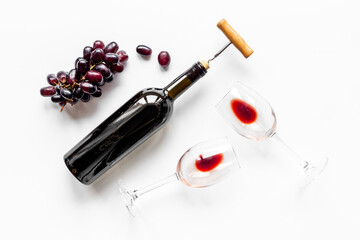 Two glasses of red wine with bottle and grape