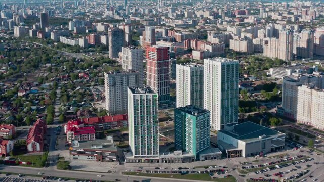 Aerial view of a beautiful big city in a morning haze. Video. Beautiful modern high rise buildings and green streets on a summer sunny day.