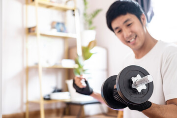 Fototapeta na wymiar Asian caucasian man hold dumbbell in home training exercise bodyweight trainer indoors workout sport exercise healthy active bodyweight fitness lifestyle