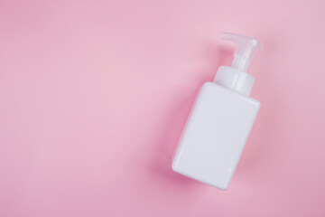 Mockup cosmetic bottle with cream or lotion isolated on pink background, mock up package for advertising, skincare or cosmetology, top view, flat lay, skin care and treatment with product.