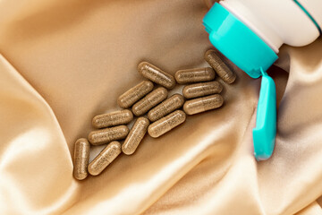 topview of super enzymes capsules on silk background. mental wellbeing and personal health concept