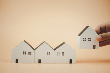 Man hand choosing wood house model,