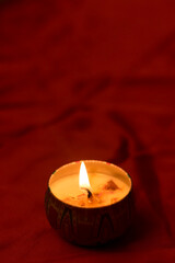 Burn a candle in a patterned pot placed on a red cloth for religion.