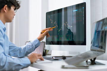 Fototapeta na wymiar Financial concept a businessman studying the stock chart analyzing the growths of the stock from the chart before investment.