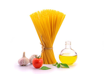 Top view of a bunch of bucatini or perciatelli - pasta, spaghetti with basil, tomatoes, garlic and...