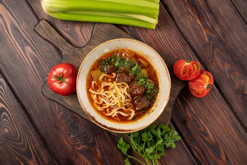 lagman with beef in tomato sauce in a deep plate, photo for the menu