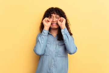 Young mixed race woman isolated on yellow background whining and crying disconsolately.