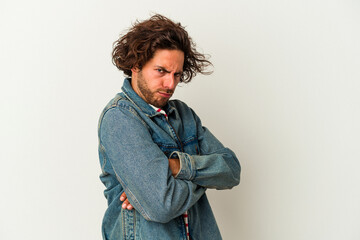 Young caucasian man isolated on white background frowning face in displeasure, keeps arms folded.