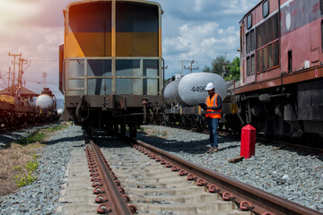 Obraz premium train on railway station. Inspection worker record list of bogie on railway. people checking bogie on railway.