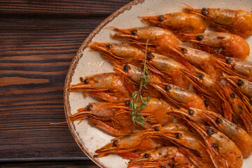 Beautifully laid out boiled tiger prawns on a plate with lemon slices and spices
