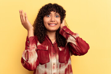 Young mixed race woman isolated on yellow background screaming with rage.