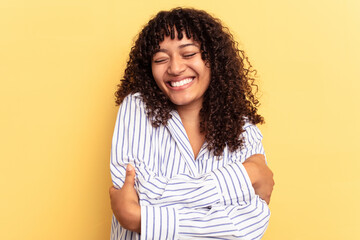 Young mixed race woman isolated on yellow background laughing and having fun.