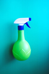 Plastic spray yellow bottle isolated on blue background. Bottle for detergent or for plant spraying. Vertical background