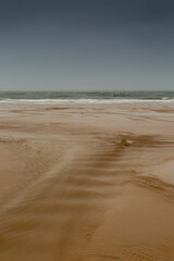Fototapeta na wymiar Fast flowing water heading out to sea in Northumberland, England, with cloudy skies overhead