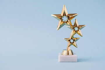 Three star awards for leader and ranking. Golden shiny prize on a pastel blue background.