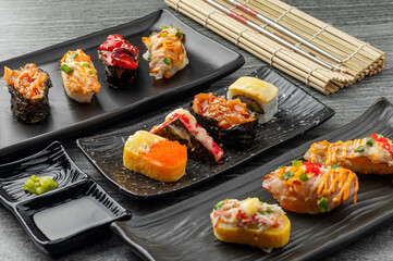 Japanese sushi set and with  shoyu soy sauce with wasabi in ceramic plate dark Placed on the table concrete grunge texture background., front view