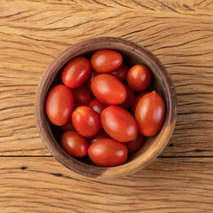 Cherry tomatoes on a bowl over wooden table
