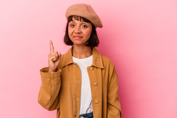 Young mixed race woman isolated on pink background showing number one with finger.