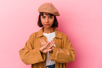 Young mixed race woman isolated on pink background standing with outstretched hand showing stop sign, preventing you.