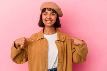 Young mixed race woman isolated on pink background points down with fingers, positive feeling.