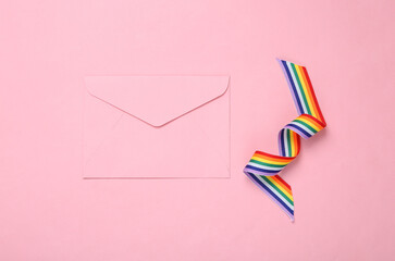 Envelope with LGBT rainbow ribbon pride tape symbol on pink background. Valentine's day, love concept