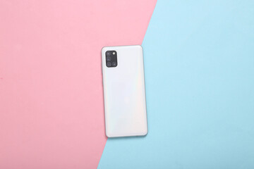 Back side of modern smartphone with four cameras on blue pink pastel background