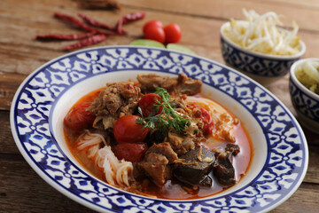 Local northern thai food Rice noodles with pork in spicy soup in wood background