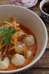 Local northern Thai food Egg noodle curry with meatballs on wood background