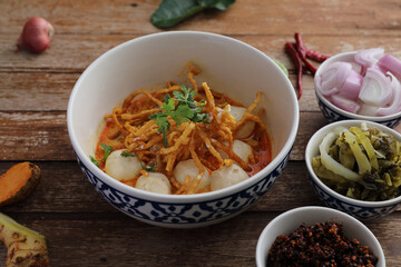 Local northern Thai food Egg noodle curry with meatballs on wood background