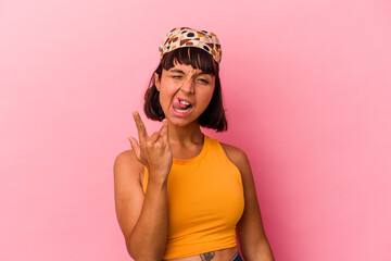Young mixed race woman isolated on pink background showing rock gesture with fingers